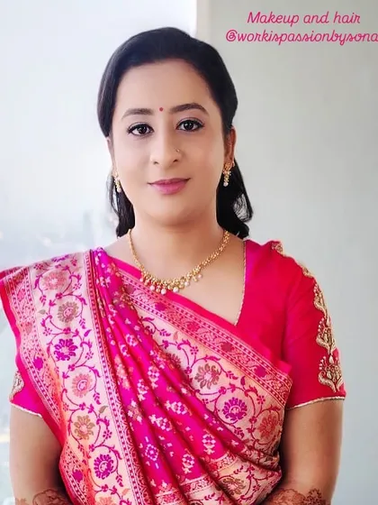 The client's complete look with a simple, wavy ponytail. This hairstyle is perfect for pairing with a beautiful saree and allows the intricate blouse details to be seen.