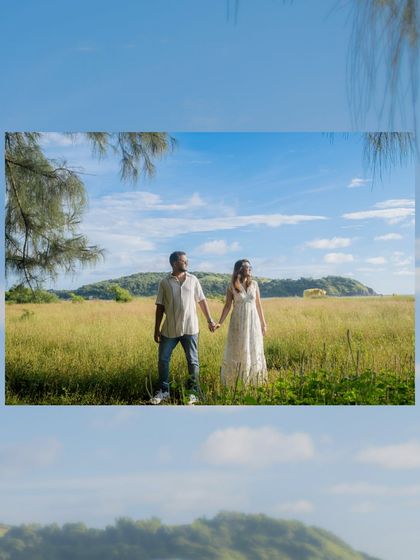 A "Windows wallpaper" moment. The vast green field, blue sky, and a distant hill created a stunning, picturesque backdrop for this couple in Goa.