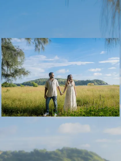 A "Windows wallpaper" moment. The vast green field, blue sky, and a distant hill created a stunning, picturesque backdrop for this couple in Goa.