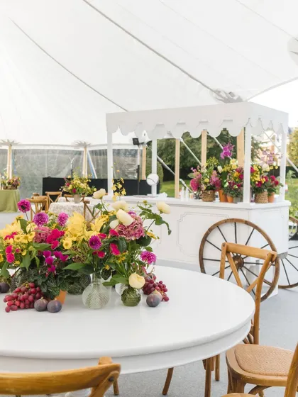 A beautiful tablescape from a countryside Mehendi, featuring fresh flowers and a charming white cart. The decor blends rustic elegance with a bright, celebratory feel.