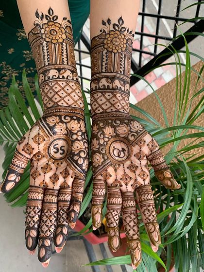 A close-up of an engagement design with the initials 'SS' and wedding rings. Personalizing the mehndi this way makes it a unique part of your love story.