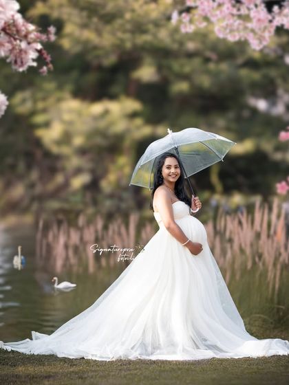 A serene lakeside portrait, with cherry blossoms and swans adding to the romantic and picturesque quality of the scene.