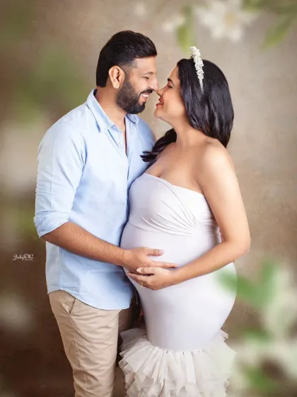 A close up, romantic shot that focuses on the couple's happy expressions. The soft, dreamy background adds to the magical feel of this maternity photo.