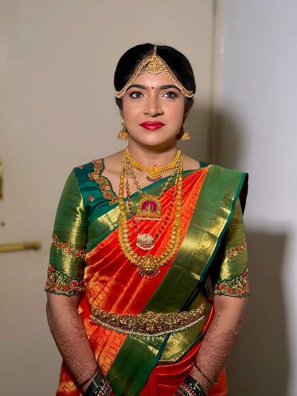 A straight-on portrait of Prerna, highlighting the symmetry and precision of her traditional bridal makeup.