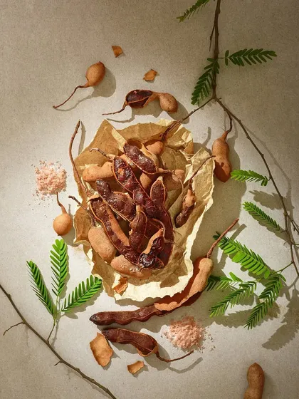 This shot is all about texture. From the brittle tamarind pods to the crumpled paper and scattered salt, every element is arranged to create a rustic and authentic feel for this nostalgic snack.