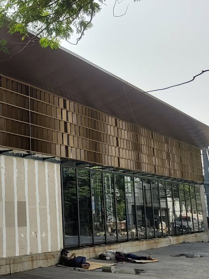 The nearly completed parametric facade alongside the raw concrete wall, showing the different layers and materials coming together.