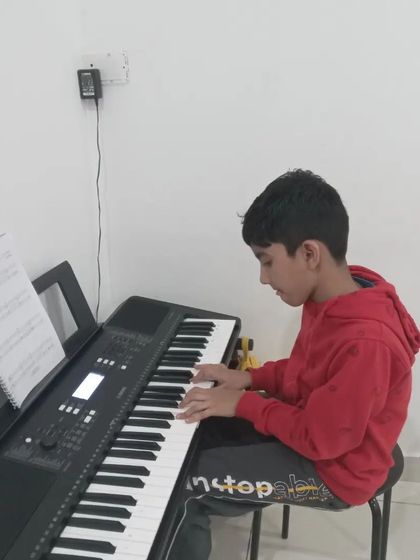 A young student enjoying his keyboard practice.