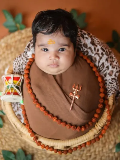 A top-down view of the little Mahadev theme, showing the baby wrapped in a basket with a damru.