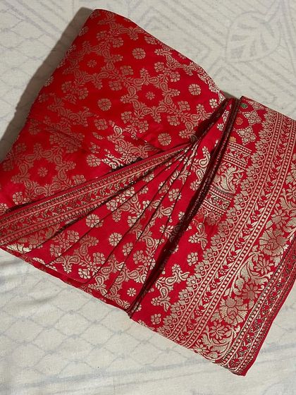 A classic red and gold Banarasi saree, a must-have in any collection. It's now perfectly pleated and ready for a wedding or puja.
