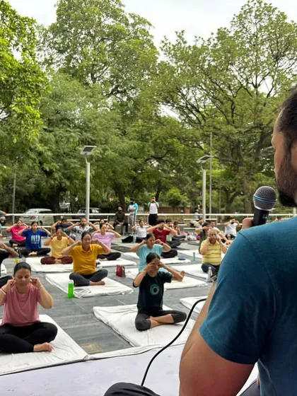 An instructor guides a large group through a pranayama technique. Clear guidance is key in our classes, ensuring everyone can follow along and receive the full benefits of the practice.