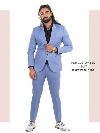 A full-length view of a custom two-piece suit in a striking sky blue, paired with a black shirt for a modern, contrasting look.