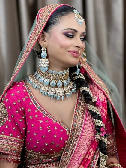 A side profile showing off the bride's intricate braided hairstyle and the elegant fall of her dupatta.