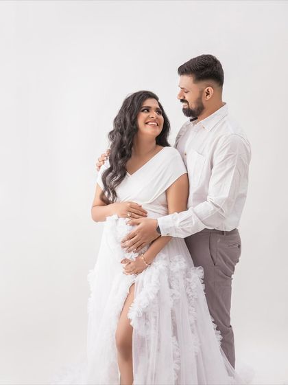 Another beautiful couple's portrait, this time against a clean white backdrop. The focus is entirely on their connection and the beautiful white gown.