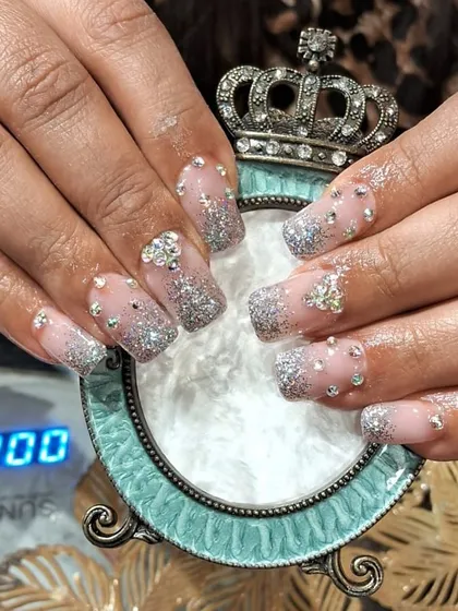 A dazzling set of square-shaped extensions with a silver glitter fade, covered in various sizes of rhinestones and 3D crystal butterfly charms.