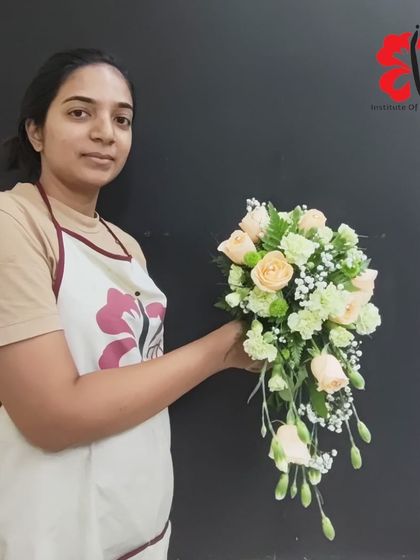 A simple yet elegant cascading bouquet made by one of our students. The soft palette of peach roses and baby's breath is a timeless choice for bridal work.