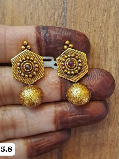 These hexagonal antique gold-plated earrings have a textured golden ball drop. The design is simple, elegant, and has a lovely vintage feel.