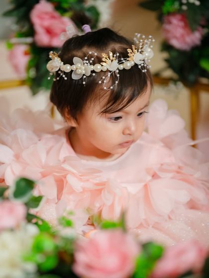 A close-up from the princess-themed birthday shoot, focusing on the child's thoughtful expression amidst the soft pink flowers and her beautiful dress.