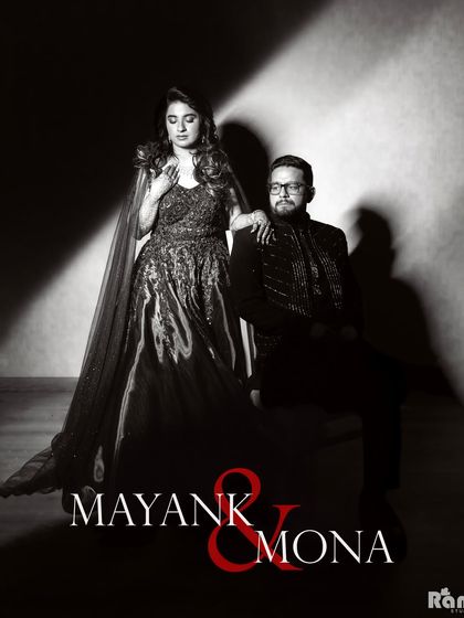 A powerful black and white studio portrait with a classic, cinematic feel. The dramatic lighting and formal pose create a timeless and sophisticated image for this couple.