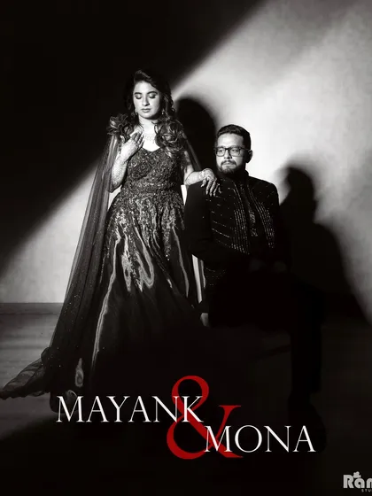 A powerful black and white studio portrait with a classic, cinematic feel. The dramatic lighting and formal pose create a timeless and sophisticated image for this couple.