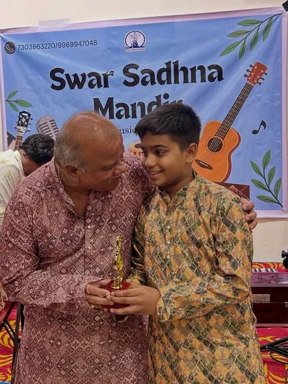 A teacher congratulates a young performer on stage. These moments of encouragement are at the heart of what we do, fostering a bond of mentorship and pride.