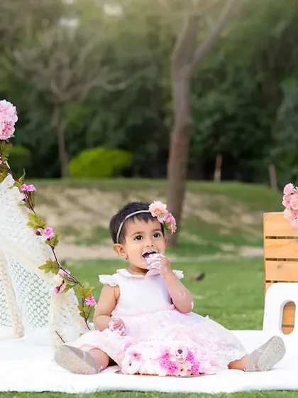 An example of an outdoor cake smash session in a Delhi-NCR park, using a beautiful floral and teepee setup for a fresh, natural feel.