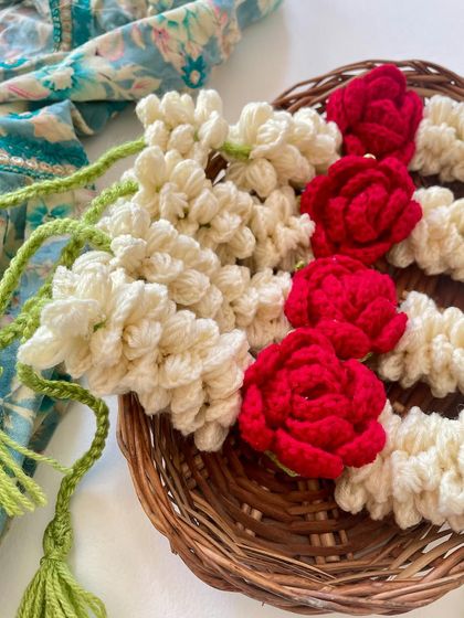 A close-up of the crochet gajra, showing the intricate details of the mogra and rose flowers.