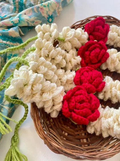 A close-up of the crochet gajra, showing the intricate details of the mogra and rose flowers.