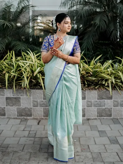 A full-length shot of the bride in her elegant saree. The soft makeup and classic hairstyle complete this beautiful and traditional look.