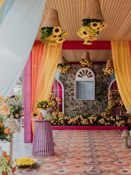 An explosion of marigold and sunflower decor, with hanging baskets and a floral wall, creating a traditional yet fresh look for a Haldi ceremony.