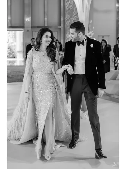 Raghav and Sanjana glide across the room, hand in hand. This black and white photo captures their elegance and the classic romance of their engagement party entrance.