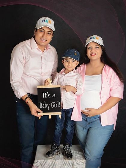 A casual and sweet gender reveal for a baby girl. The family's coordinated outfits and the son holding a little chalkboard make this a heartwarming family announcement.
