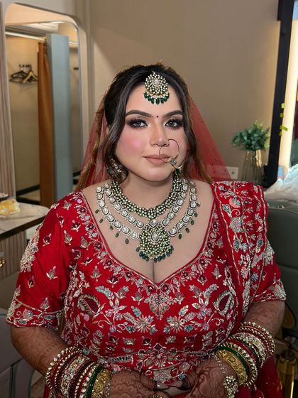 A closer look at this bride's glamorous makeup. The heavy kundan and emerald jewellery is balanced with a strong eye look and a perfectly sculpted face.