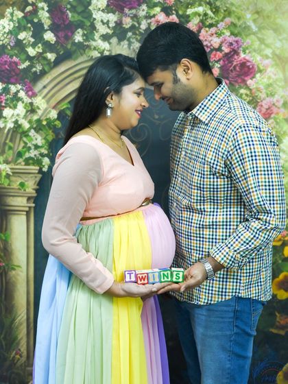 A sweet couple's portrait, holding "TWINS" blocks to celebrate their double blessing.