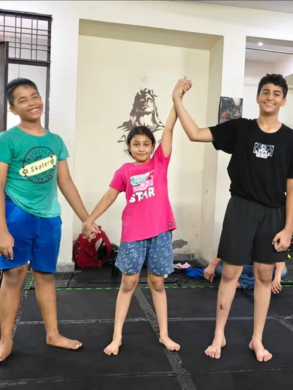 The process of learning is a team effort. These students stand together, supporting each other's growth in our kids' MMA program.