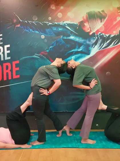 A slight variation of the four-person partner pose, demonstrating how small adjustments can change the dynamics and feel of the asana.