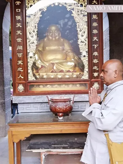 Praying before a statue of the laughing Buddha. This is a part of Chan meditation, cultivating a spirit of contentment and peace.