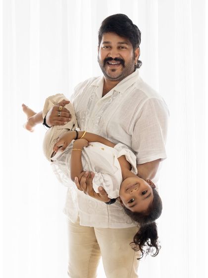 A father playfully holding his daughter upside down, both of them laughing. These are the fun memories you'll want to keep forever.