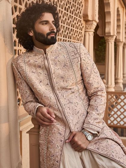 A detailed view of the sherwani's fabric and embroidery. The subtle texture and meticulous threadwork are hallmarks of my bespoke creations.