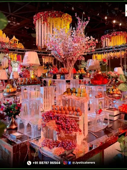 A spectacular and abundant fruit display, artfully arranged on multi-level acrylic stands, serves as both a healthy treat and a stunning centerpiece for the event.