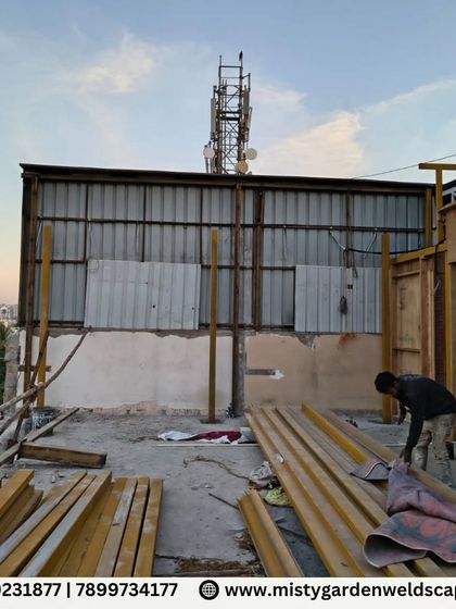 The worksite during the initial stages of a pergola installation. You can see the raw materials and the beginning of the assembly, highlighting the start of the transformation.