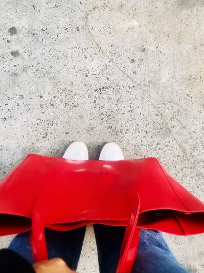 Even on a gloomy day, a pop of color can lift your spirits. Adding a bold red tote bag to a simple jeans-and-sweater outfit is an easy way to infuse energy and personality into your look.