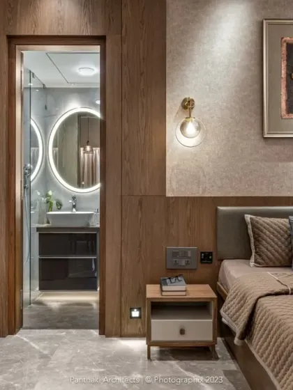 We designed this bedroom to be a complete suite, with a clear view into the modern, well-lit bathroom. The consistent use of materials and color creates a harmonious and expansive feeling.