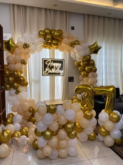 A wider shot of the elegant 37th birthday setup, showing the full circular balloon arch and cake table.
