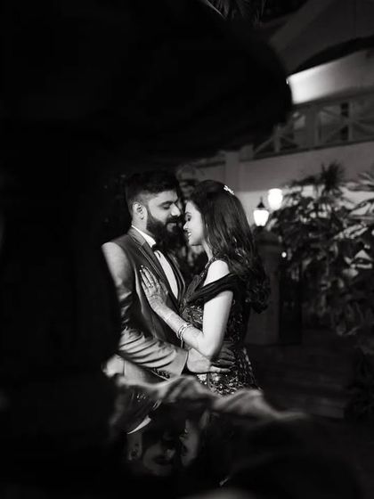 A duplicate of image 47, a romantic black and white photo of a couple at night, framed by a fountain.