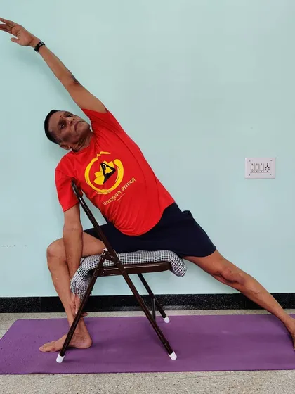 Utthita Parsvakonasana (Extended Side Angle Pose) on a chair. This helps to learn the correct lateral extension of the spine and opening of the hip without bearing full body weight.