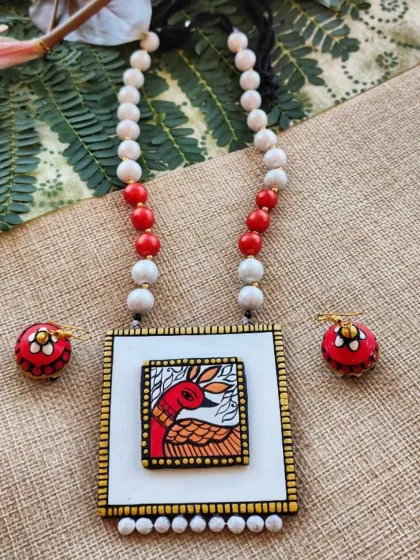 Here is another version of my Gond art series, featuring a bird motif in warm reds and oranges. The square pendant is framed with delicate dots and paired with colorful beads and matching jhumkas, making it a bright and artistic piece.