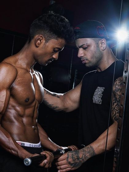 Coaching is about guidance and correction. Here, I'm adjusting my client's form on a cable curl to ensure maximum muscle activation and prevent injury.