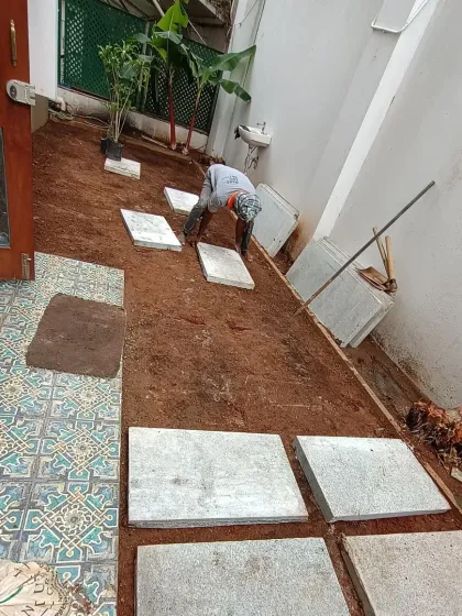 Here, a member of my team is carefully placing large stone slabs to create a modern, geometric pathway through the garden.