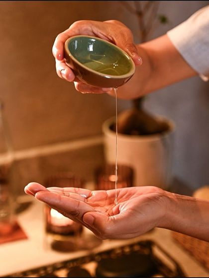 I believe in the power of pure ingredients. Here, a therapist prepares a warm, aromatic oil, the foundation of many of my nourishing body treatments and massages that soothe both skin and soul.