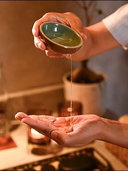 I believe in the power of pure ingredients. Here, a therapist prepares a warm, aromatic oil, the foundation of many of my nourishing body treatments and massages that soothe both skin and soul.